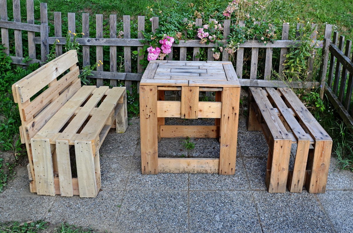 Ein Tisch und zwei BÃ¤nke in einem Garten, aus Euro-Paletten gebastelt.