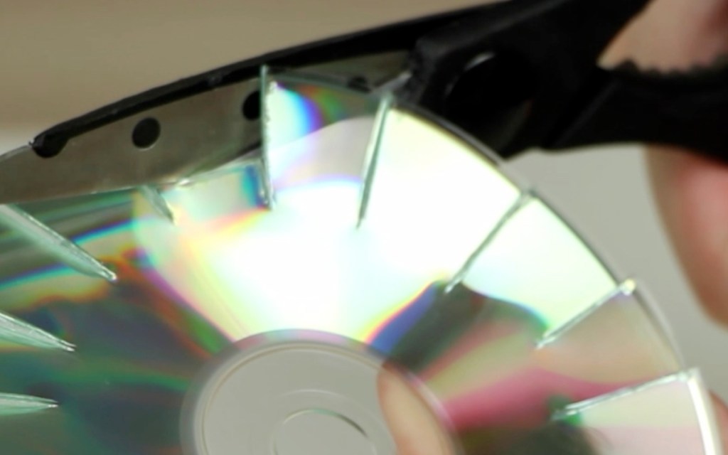 Eine CD-Rom wird mit einer Schere zerschnitten.