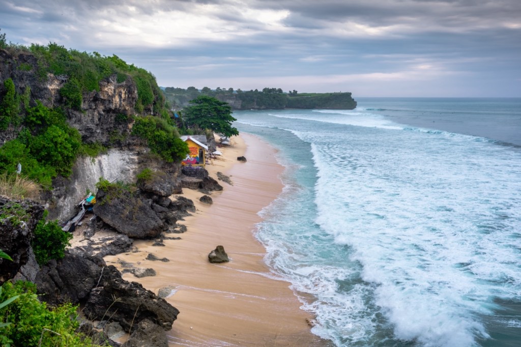 Ein indonesischer Strandabschnitt mit einer kleinen Hütte am Strand.