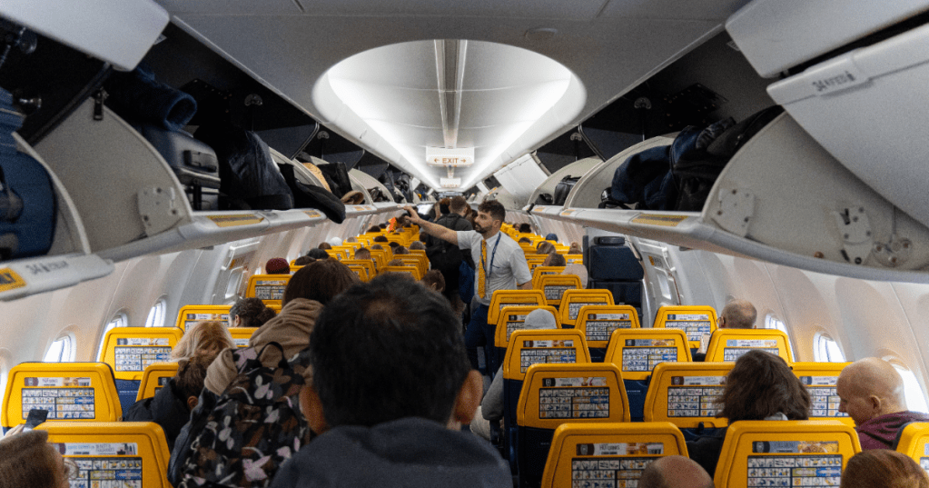 Viele Menschen beim Einstiegen und Sitzplatzsuche in einem Flugzeug. 