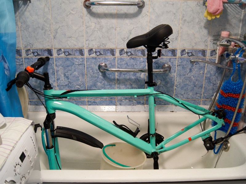 Ein Fahrrad steht in einer Badewanne und wird repariert und geputzt.