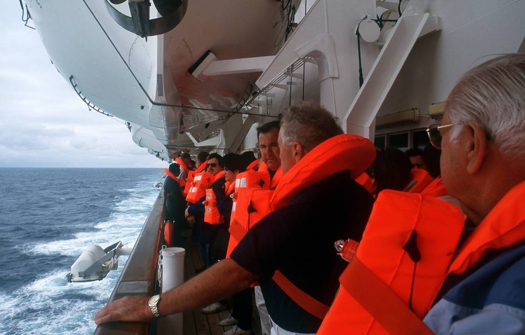 Passagiere auf einem Kreuzfahrtschiff in Rettungswesten.