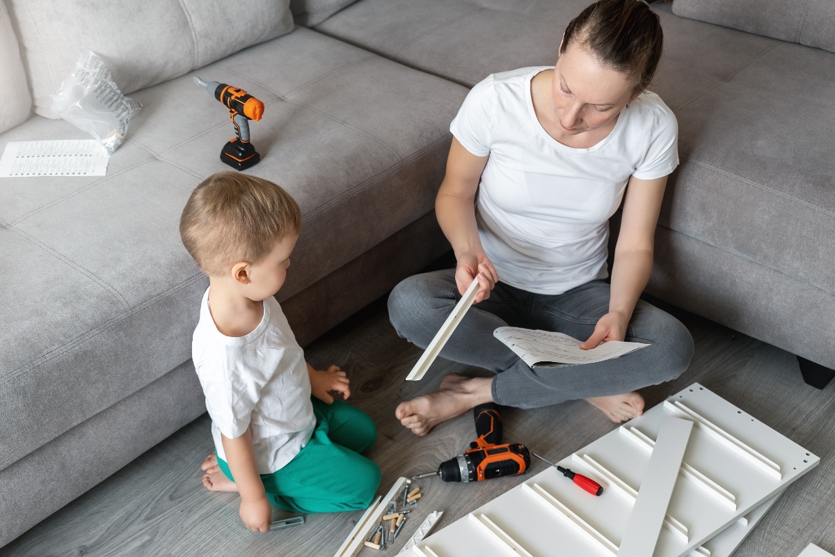 Eine Mutter baut mit ihrem Kind ein Möbelstück von IKEA auf.