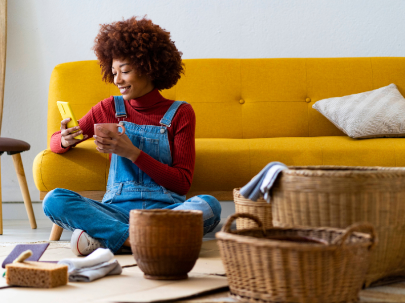 Frau mit Tasse und Handy bastelt