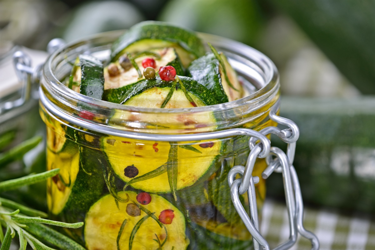 Eingelegte Zucchini mit KrÃ¤utern in einem Einmachglas.