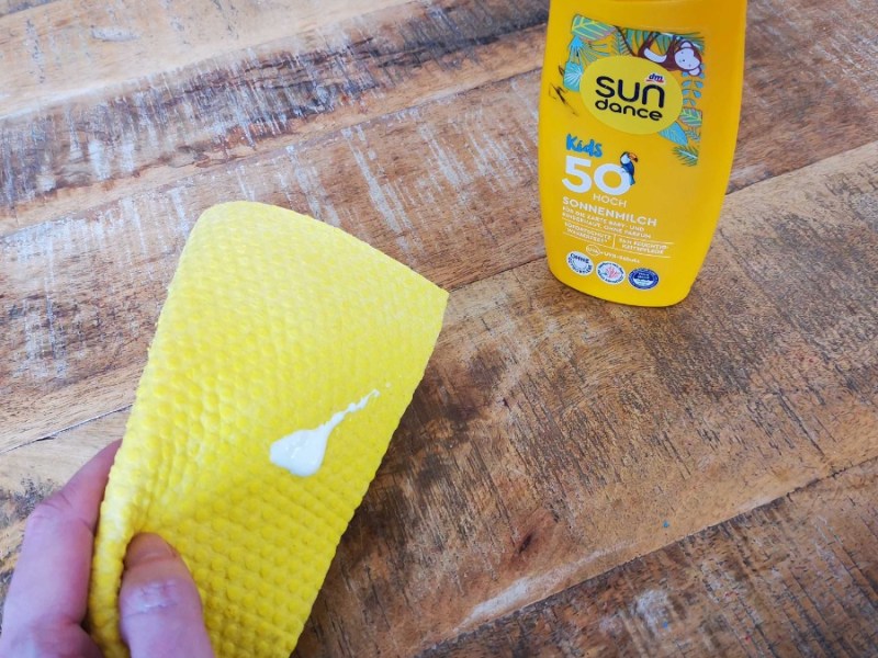 Ein Klecks Sonnencreme auf einem gelben Wischtuch