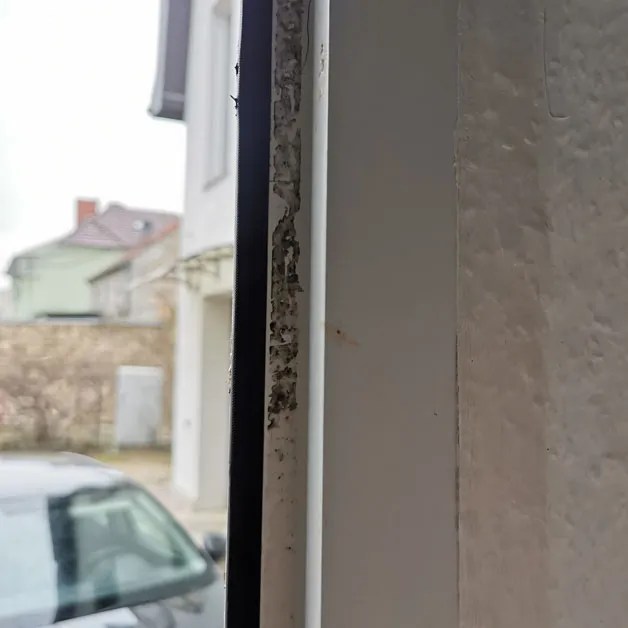 Hartnäckig verschmutzter Rahmen eines Kunststofffensters