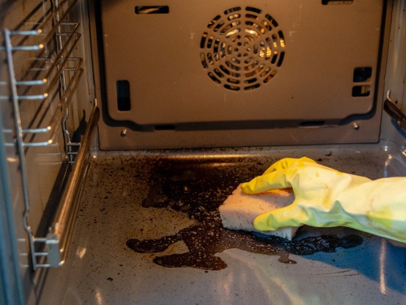 ein dreckiger Backofen wird geputzt