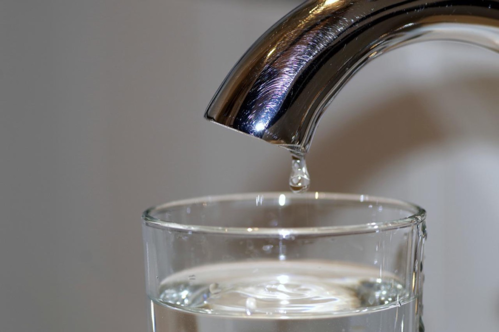 Glas Leitungswasser unter einem Wasserhahn.