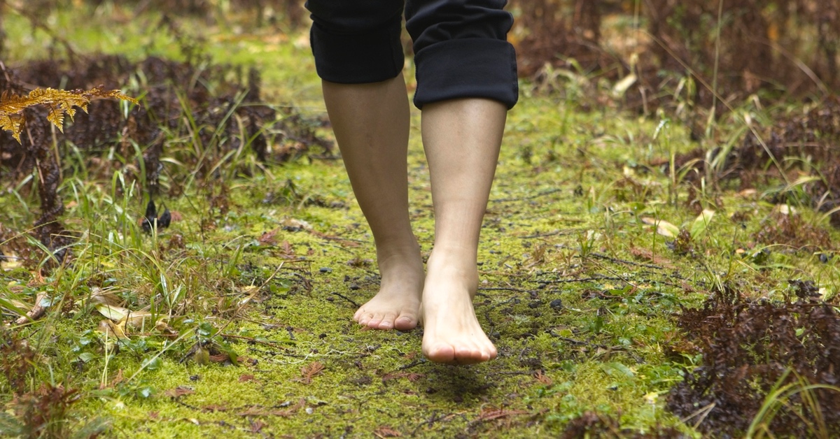 Jemand läuft barfuß durch den Wald.