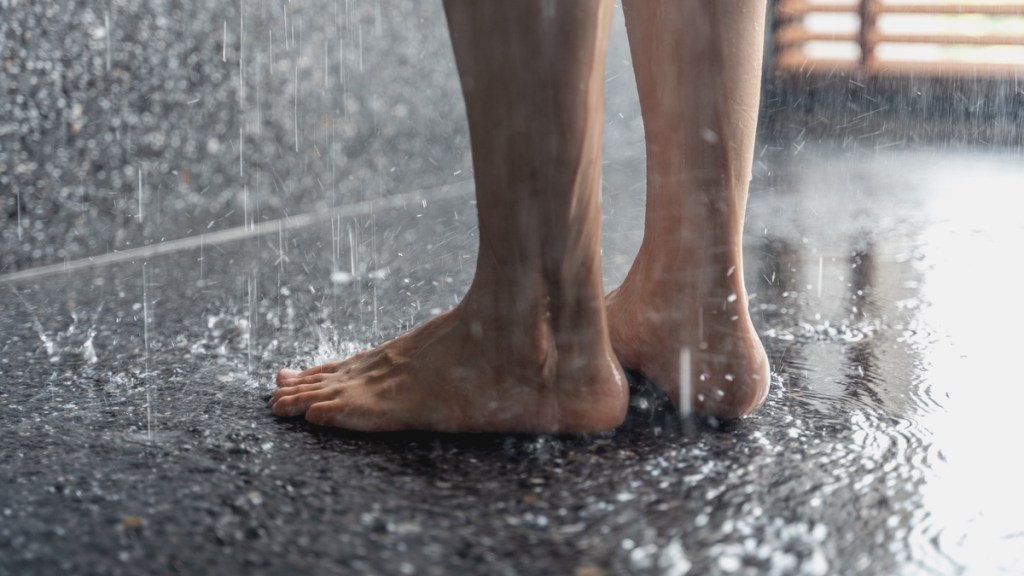 Jemand steht barfuß in einer Dusche.