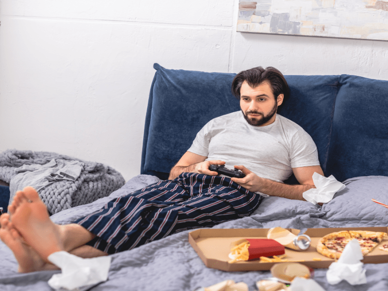 Mann liegt im dreckigen Bett