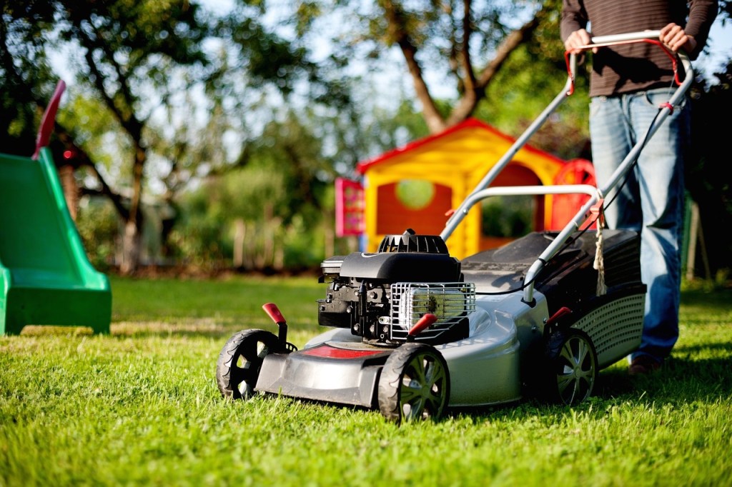 Ein Mann mäht den Rasen in seinem Garten.