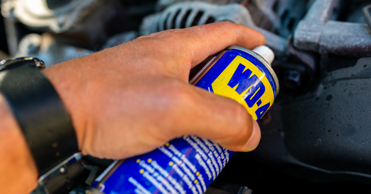 Eine Hand hÃ¤lt eine Dose WD-40 Ã¼ber eine verrostete Stelle