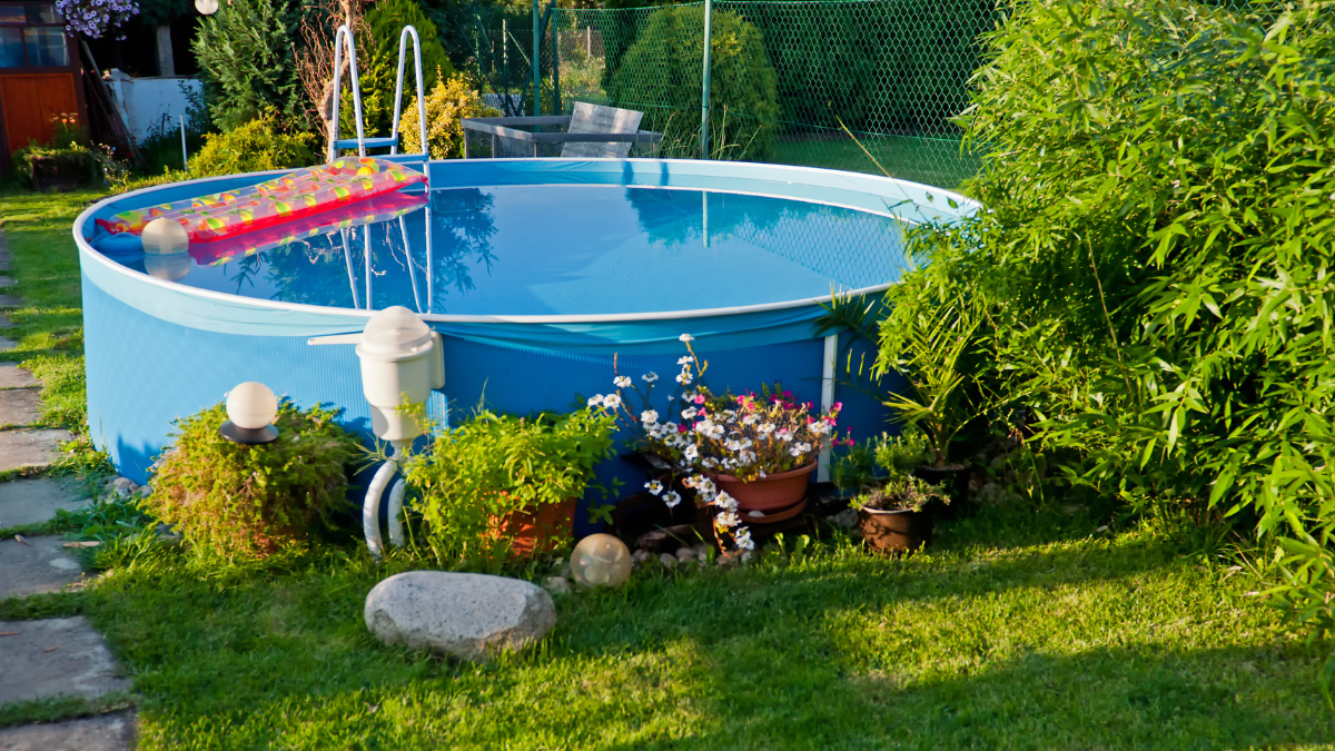 Ein aufgestellter blauer Pool im Garten.