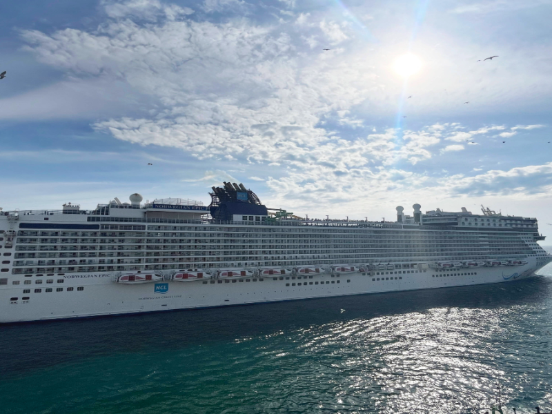 Ein Kreuzfahrtsschiff auf dem Wasser in der Sonne.