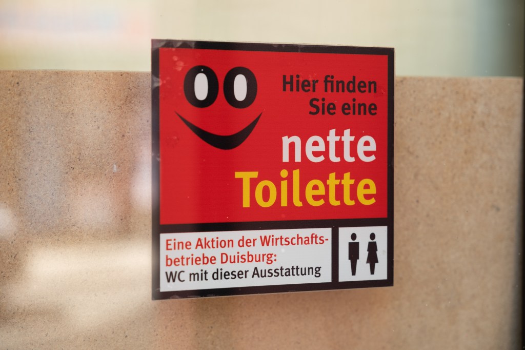 Schild macht Werbung für das Konzept „nette Toilette“.