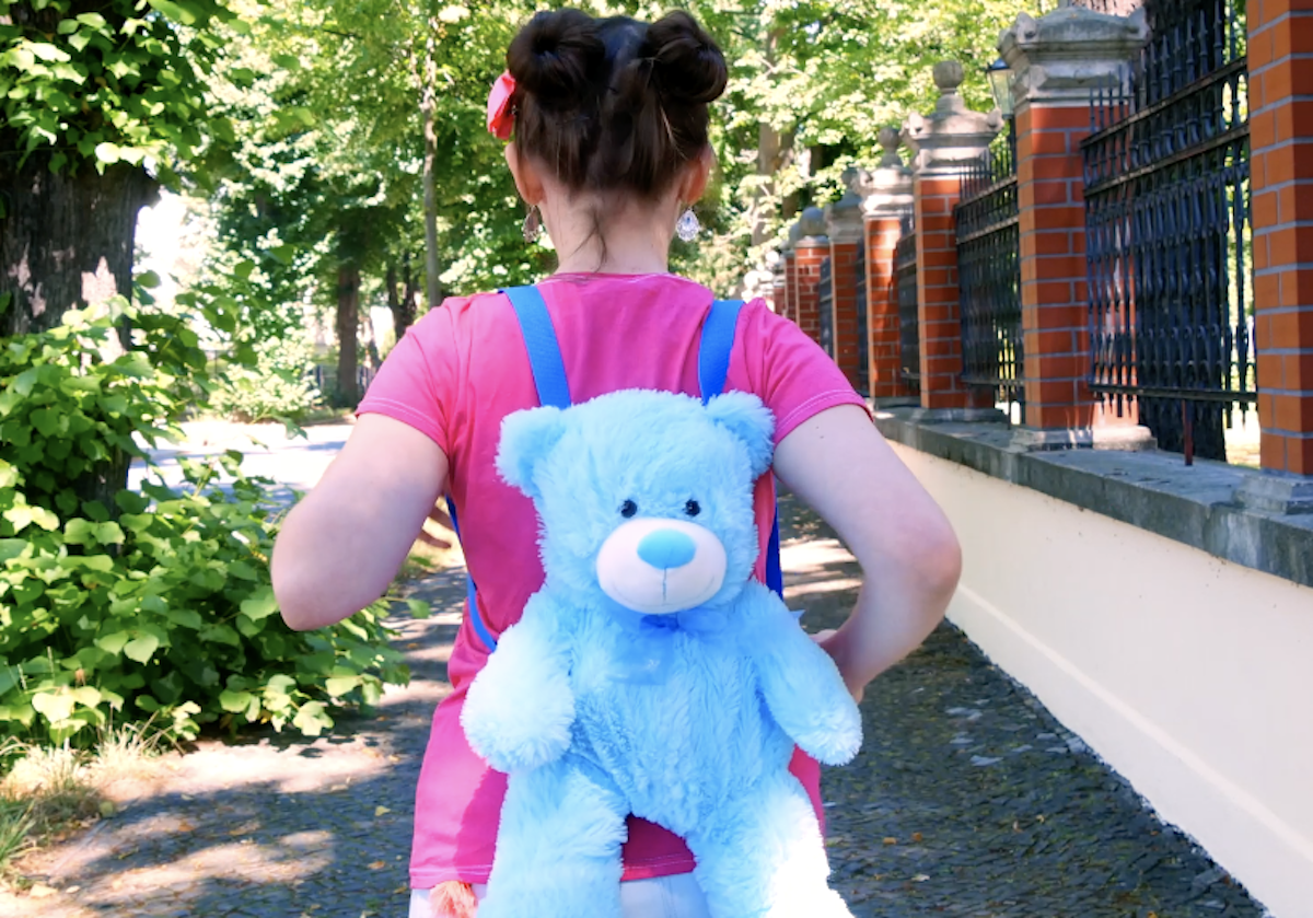 Mädchen trägt Rucksack, gebastelt aus einem Kuscheltier.