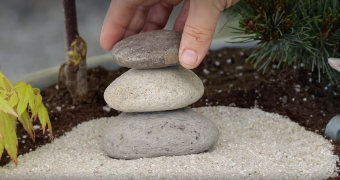 Eine Steinskulptur in einem Mini-Zengarten.