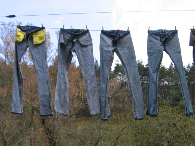 Vier auf links gedrehte Jeans hÃ¤ngen zum Trocknen auf einer WÃ¤scheleine.