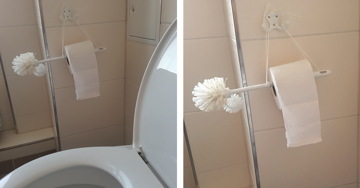 Klorollenhalterung aus einer Klobürste hängt neben der Toilette.