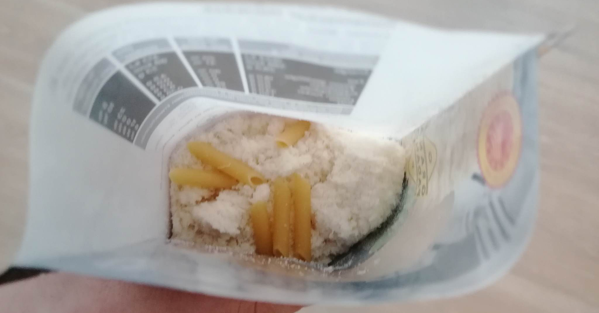 In einer geöffneten Packung Parmesankäse liegen einige ungekochte Nudeln. Dieser Trick soll den Parmesan länger haltbar machen.