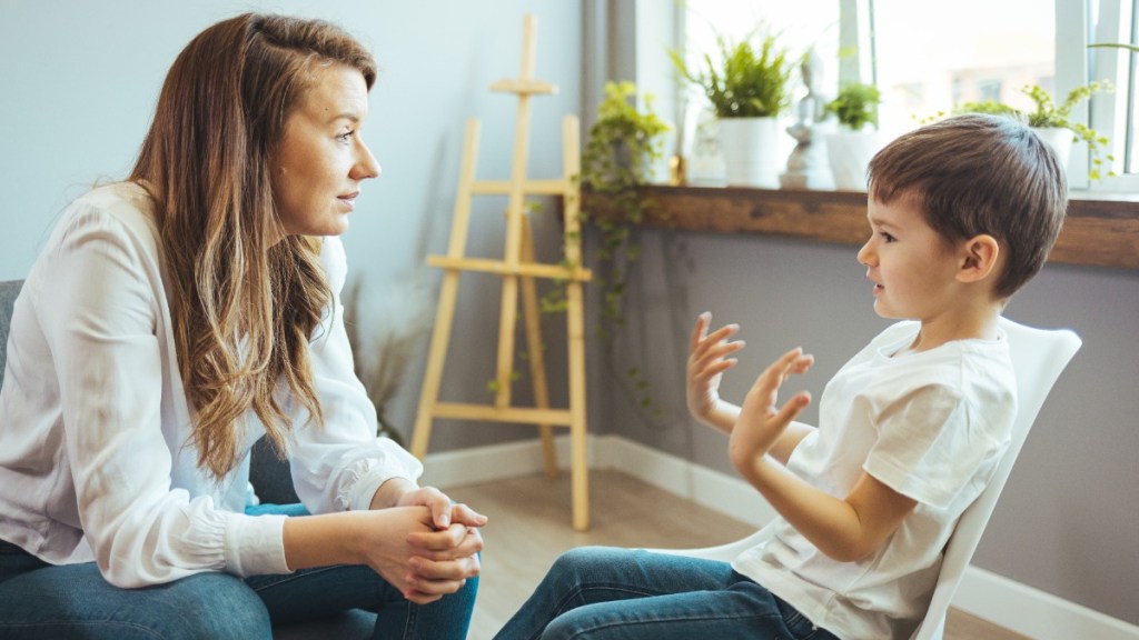 Mutter und Sohn sitzen sich gegenüber und unterhalten sich