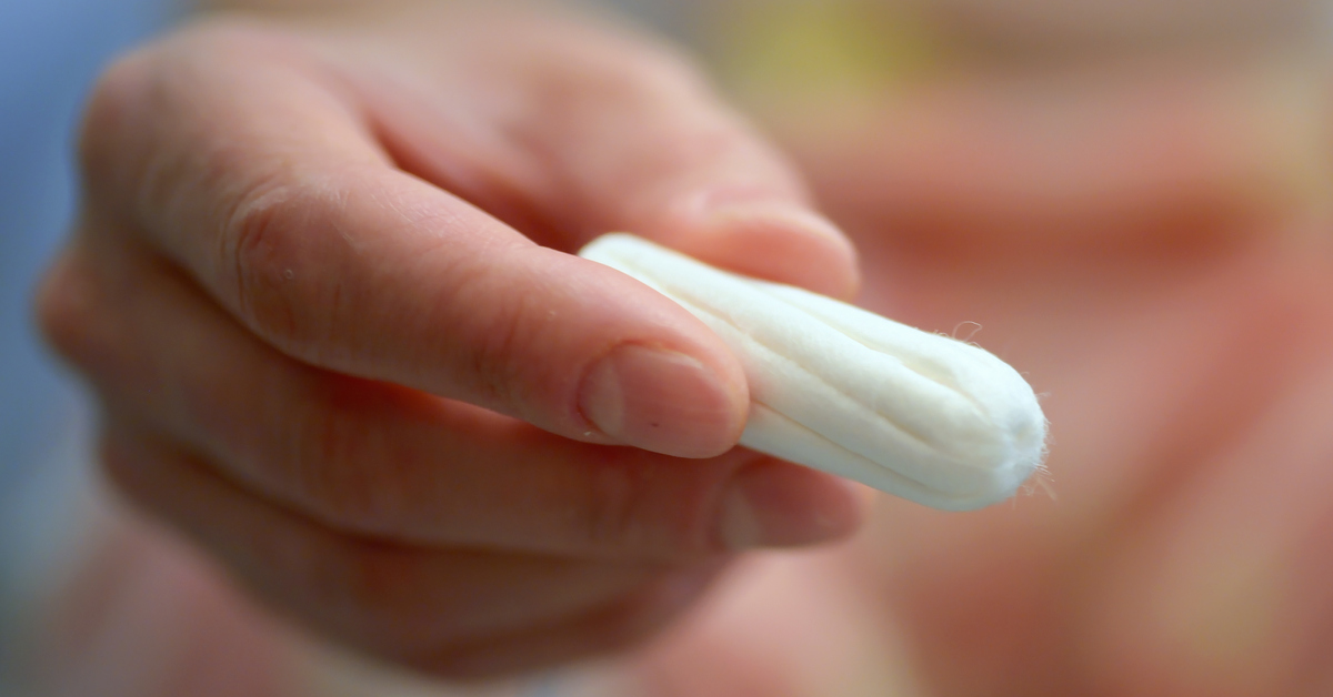 Eine Hand hÃ¤lt ein offenes unbenutztes Tampon in die Kamera.