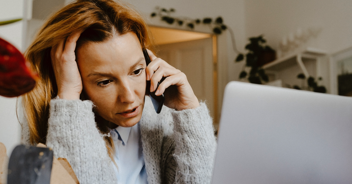 Eine Frau telefoniert am Handy und hat dabei einen besorgten Gesichtsausdruck.