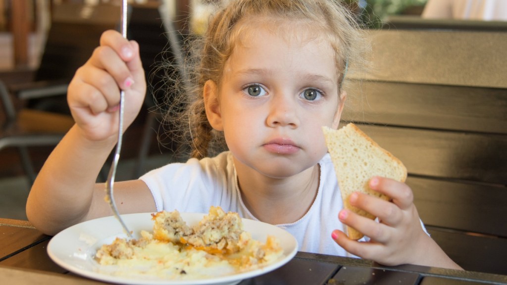 Ein Mädchen mit Essen im Restaurant.