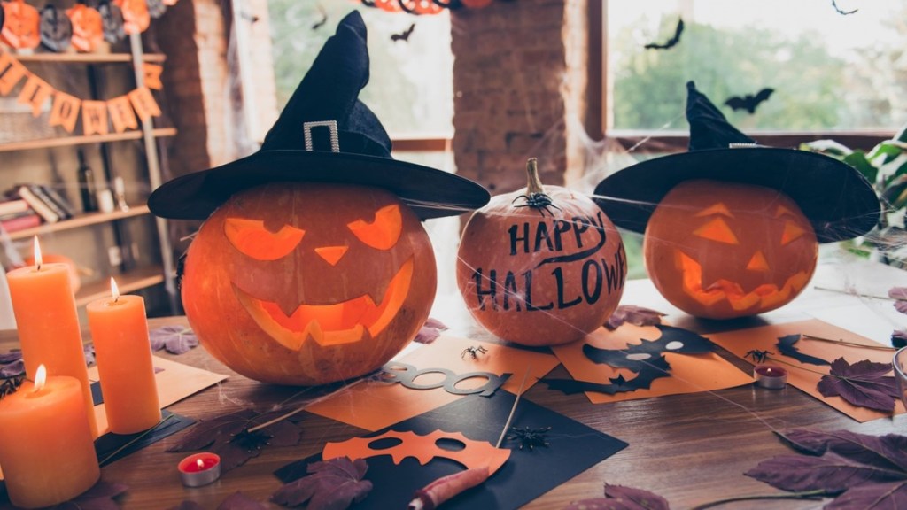 Kürbisse und weitere Halloween-Deko auf einem Tisch.