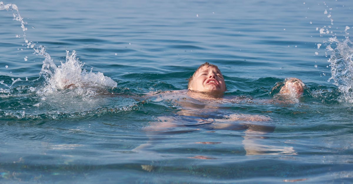 Jugendlicher mit verängstigtem Gesichtsausdruck im Wasser.