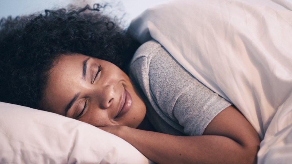 Frau schläft friedlich im Bett.