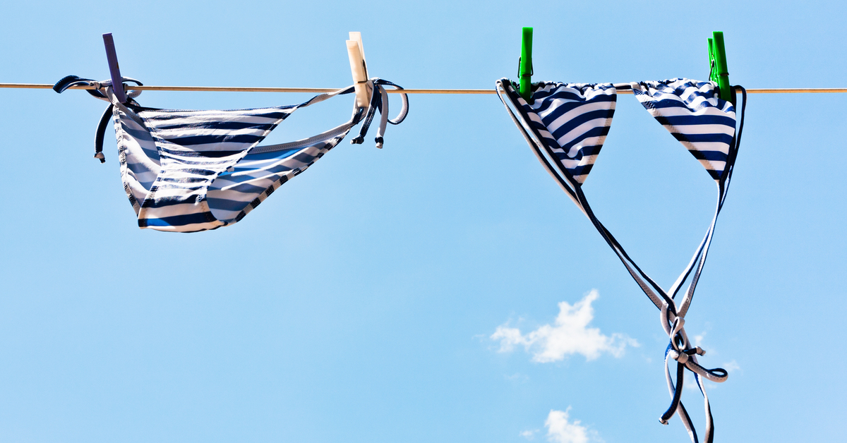 Ein blau-weiÃŸ gestreifter Bikini hÃ¤ngt an einer WÃ¤scheleine.