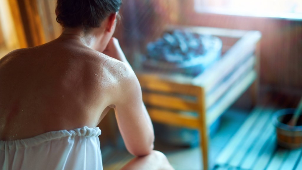 Frau schwitzt in der Sauna.