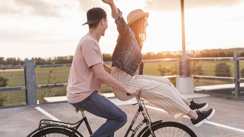 Zwei junge Menschen auf einem Fahrrad.