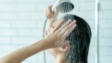Eine Frau steht unter der Dusche und wäscht sich ihre Haare.
