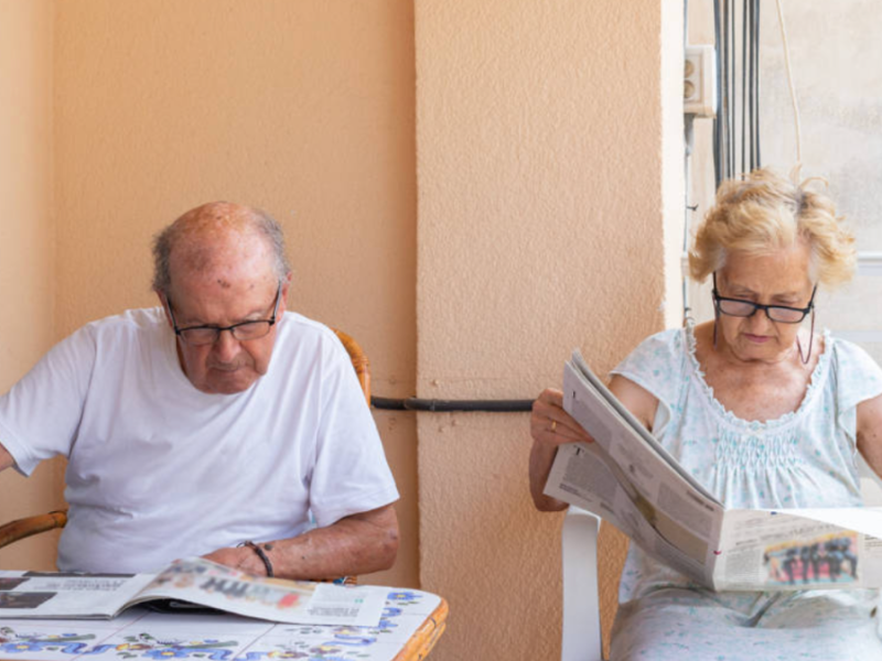 Ein älteres Ehepaar, das Zeitung liest.