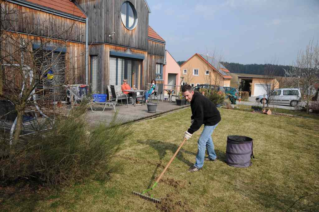 Mann auf einem Rasen mit einem Rechen 