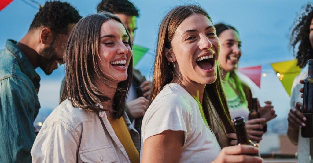 Zwei junge Frauen tanzen auf einer Party.