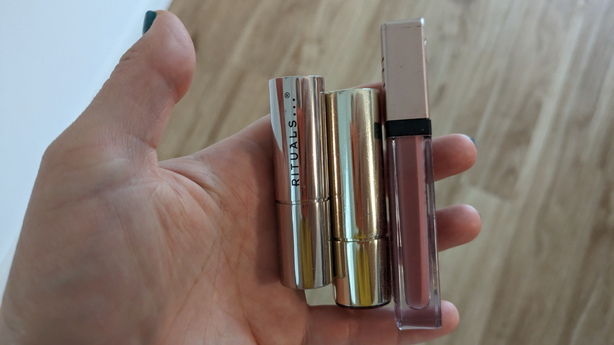 Mehrere Lippenstifte werden in die Kamera gehalten.