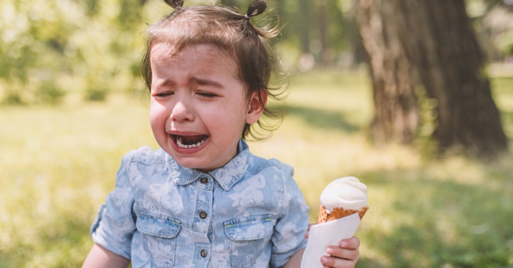 kleines Mädchen mit einem Eis in der Hand weint bitterlich