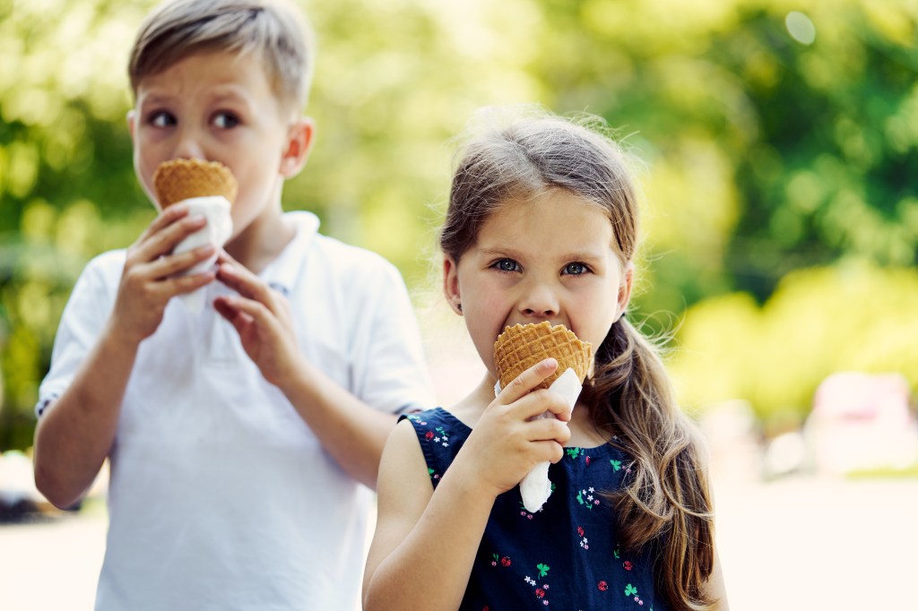 Zwei Kinder essen ein Eis in der Waffel.