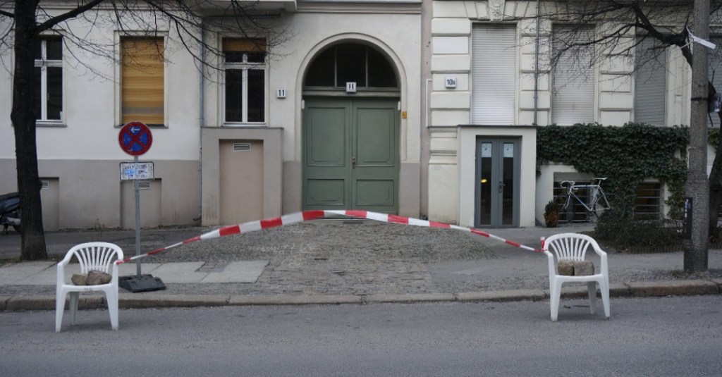 zwei Stühle mit einem Absperrband dazwischen stehen auf der Straße