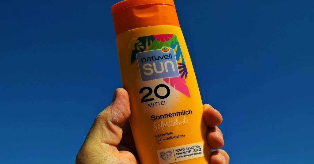 Sonnencreme in der Hand halten