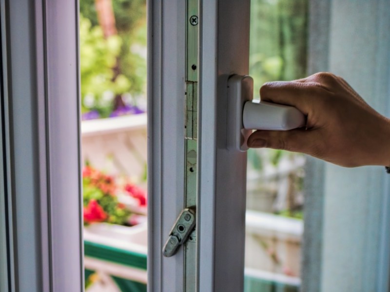 Eine Hand öffnet ein Fenster