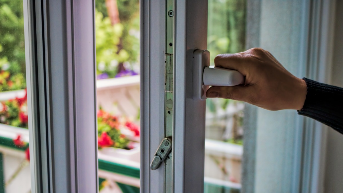 Eine Hand öffnet ein Fenster