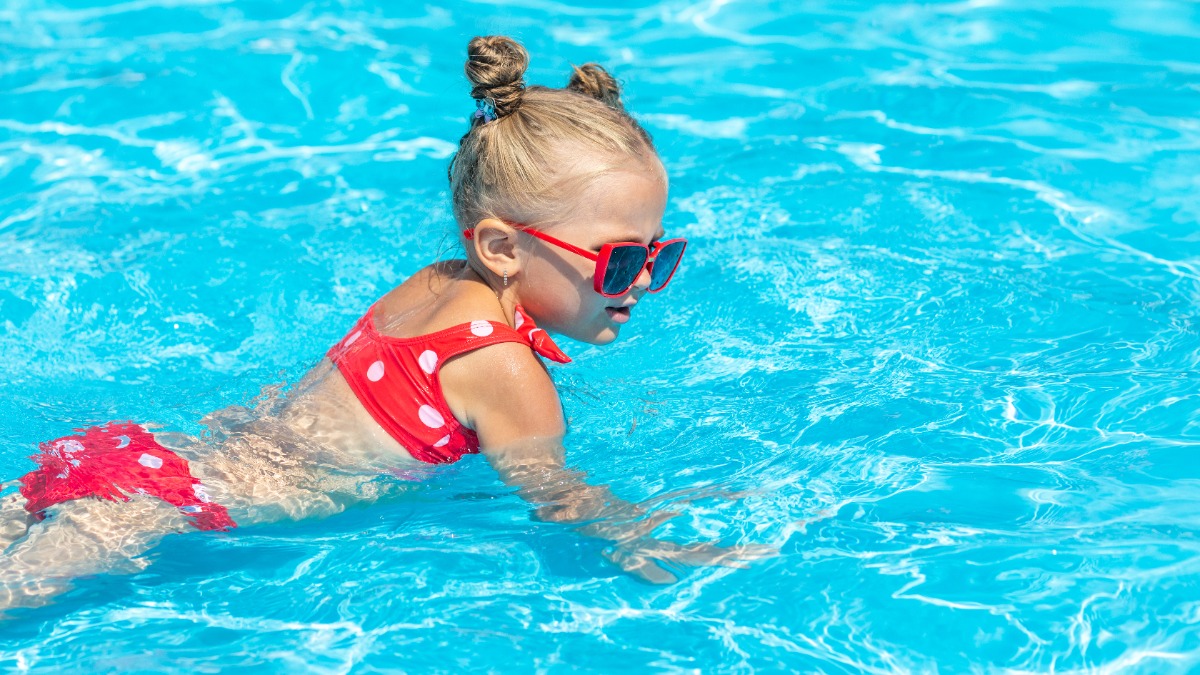 MÃ¤dchen im rosa Bikini planscht im Wasser