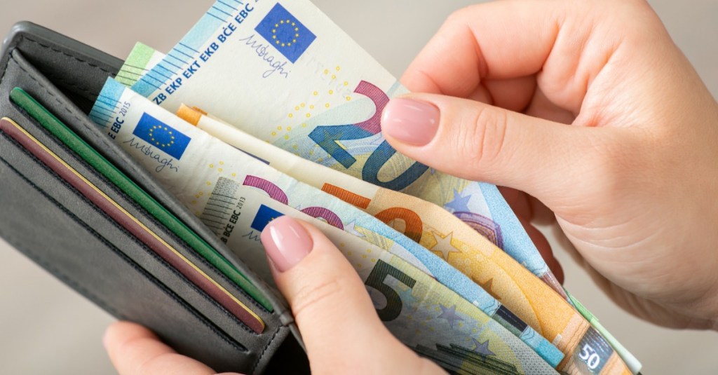 Frauenhand hält ein gefülltes Portemonnaie in der Hand