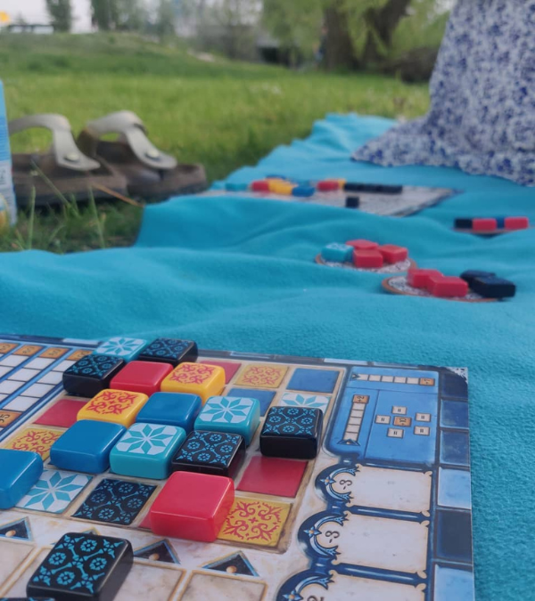 Das Legespiel Azul auf einer blauen Decke im Park.